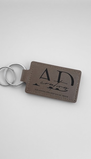Grauer genähter Leder-Schlüsselanhänger mit graviertem Logo von AD creatives